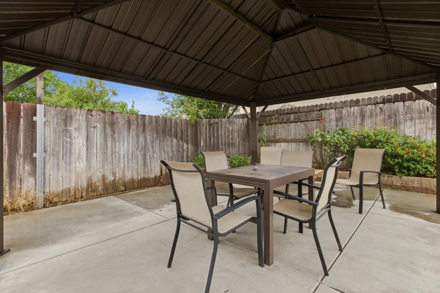 969 Colson Way Galt, CA 95632 - Photo 35 of 38 a view of patio with table and chairs under an umbrella