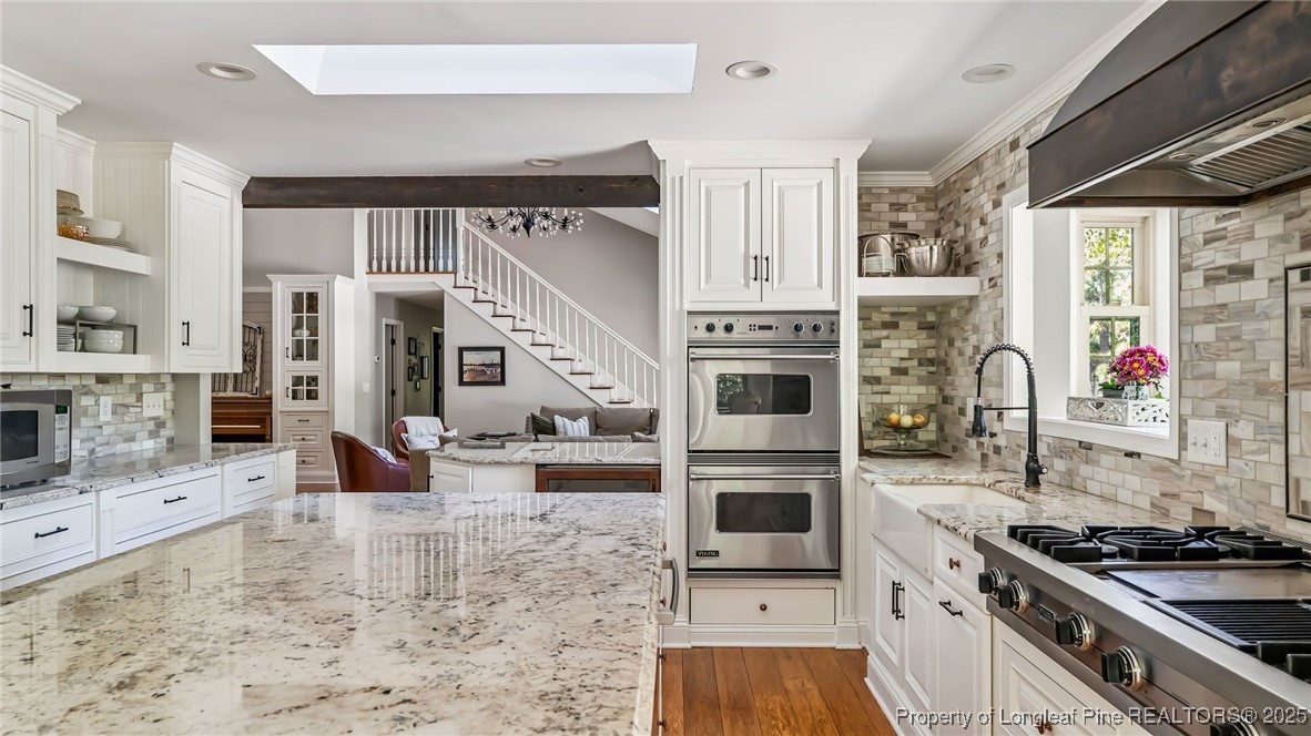 1336 McCaskill Road Carthage, NC 28327 - Photo 13 of 48 a kitchen with stainless steel appliances kitchen island granite countertop a stove a sink and a microwave