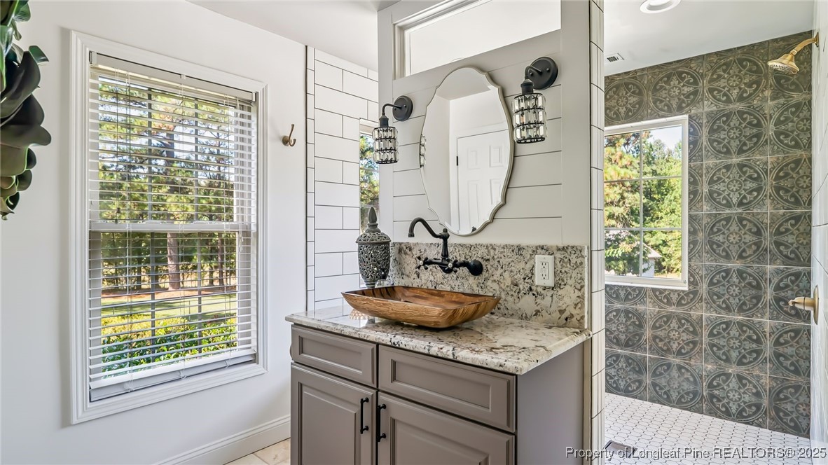 1336 McCaskill Road Carthage, NC 28327 - Photo 22 of 48 a bathroom with a granite countertop sink a mirror and a shower