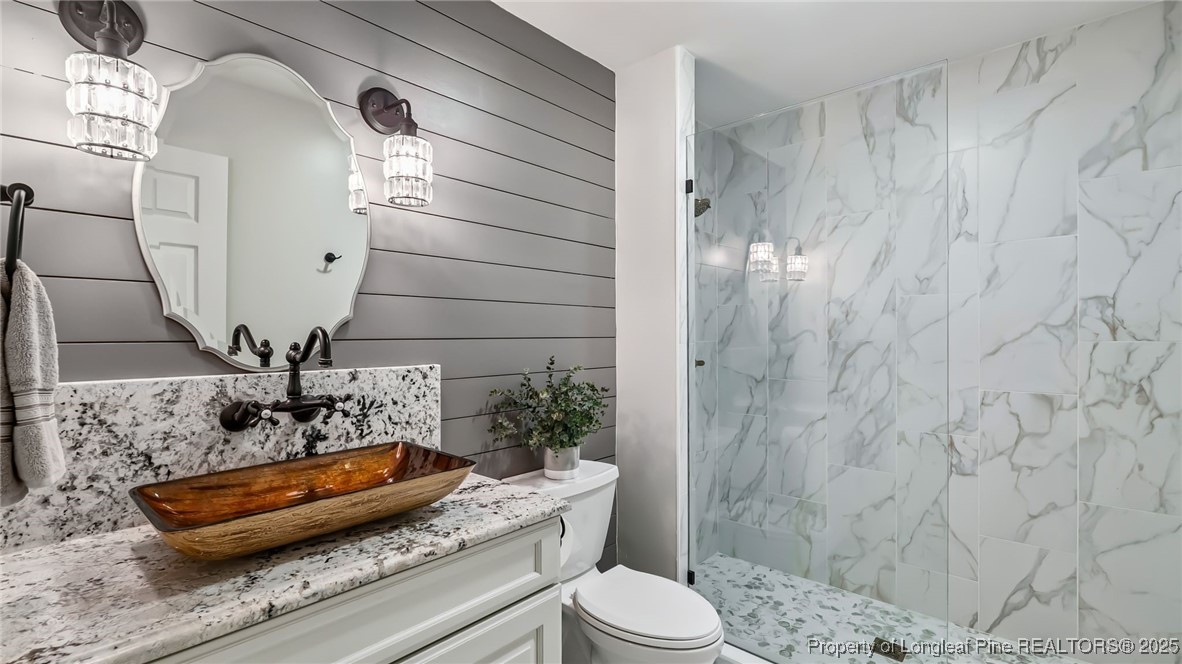 1336 McCaskill Road Carthage, NC 28327 - Photo 25 of 48 a bathroom with a granite countertop sink a toilet and shower