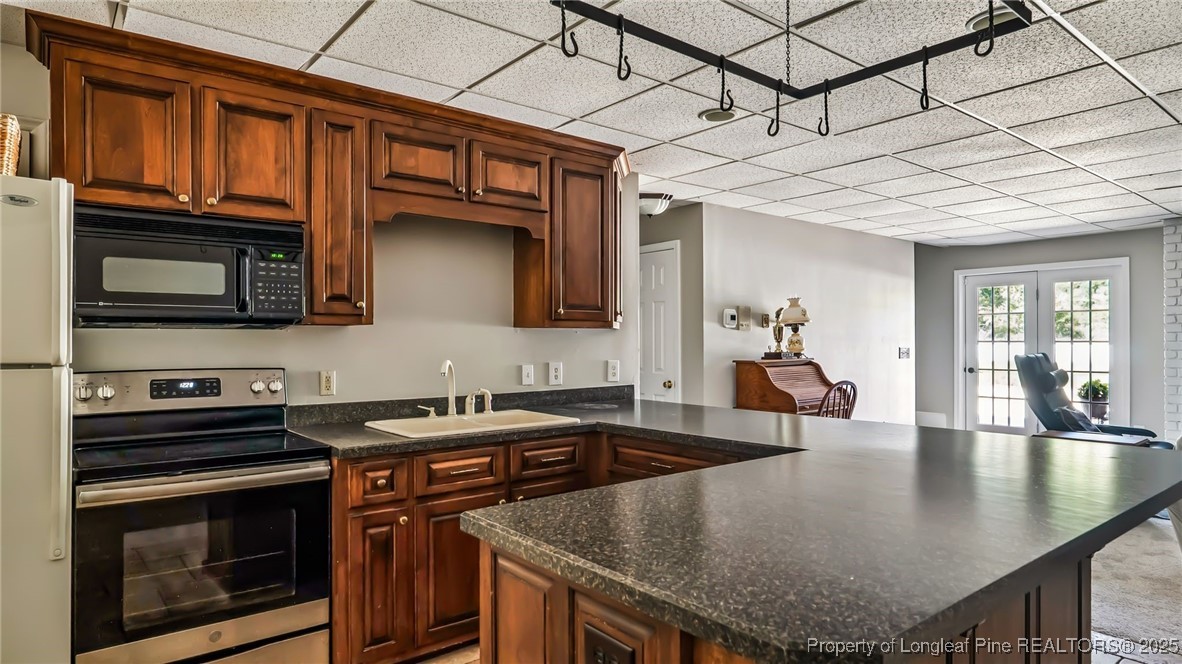 1336 McCaskill Road Carthage, NC 28327 - Photo 32 of 48 a kitchen with stainless steel appliances granite countertop a sink a stove and microwave