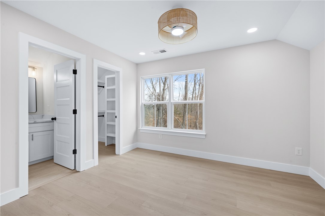 322 Oconee Avenue Westminster, SC 29693 - Photo 25 of 42 This bright bedroom features a window overlooking mature trees and a functional closet.
