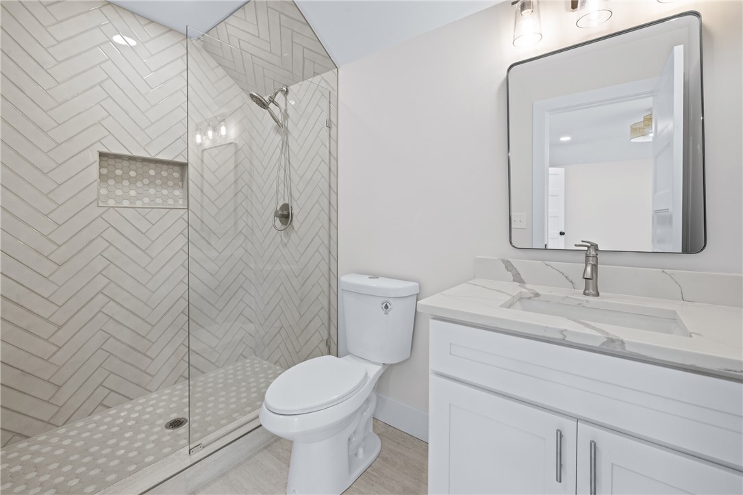 322 Oconee Avenue Westminster, SC 29693 - Photo 27 of 42 This bright bathroom features a modern vanity with elegant countertops and a spacious walk-in shower.