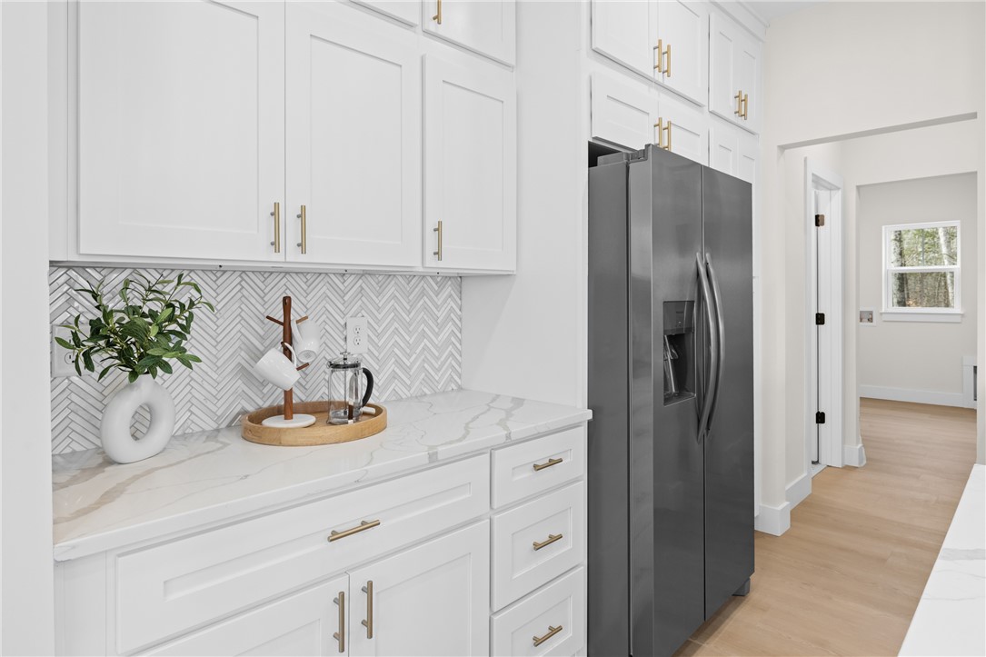 322 Oconee Avenue Westminster, SC 29693 - Photo 7 of 42 This modern kitchen boasts sleek white cabinetry, a stylish backsplash, and ample counter space.