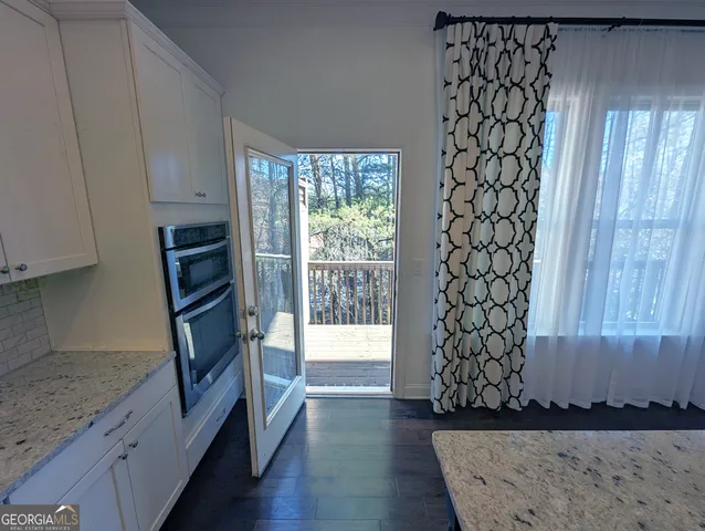 a bathroom with a granite countertop sink a mirror and a bathtub