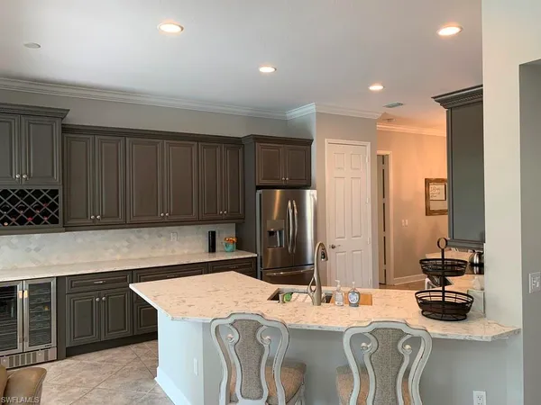 a kitchen with a refrigerator a stove and a sink with wooden cabinets
