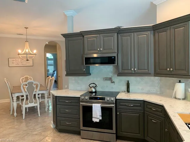 a kitchen with stainless steel appliances a stove a sink cabinets and a dining table