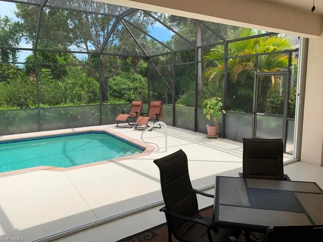 a view of a patio with a table chairs and a backyard