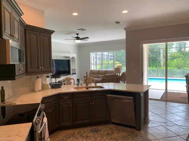 a kitchen with a sink a counter top space appliances and cabinets