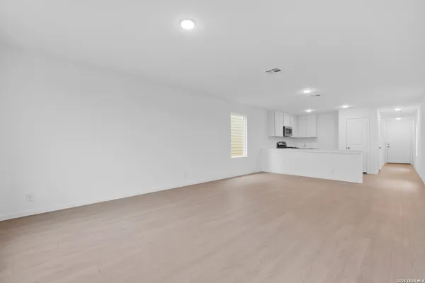 a view of empty room with kitchen