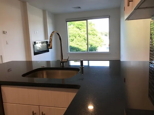 a close view of a sink a counter space and utility room
