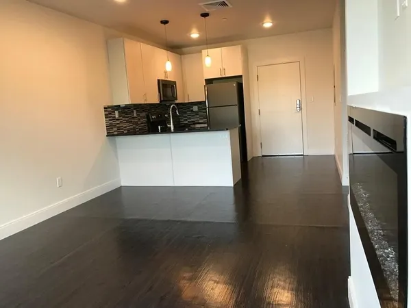 a view of kitchen with a sink refrigerator and wooden floor