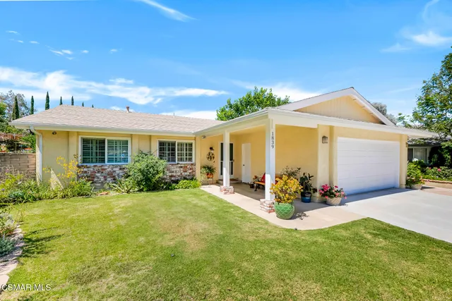 a view of a chair and table in backyard of the house