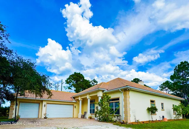a view of a house with potted plants in front of door