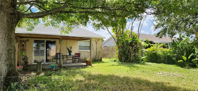 a view of a chair and table in backyard of the house