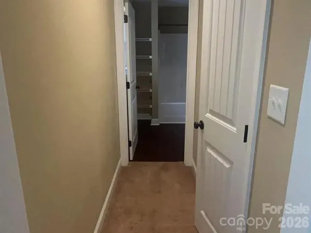 a view of a hallway with wooden floor and closet