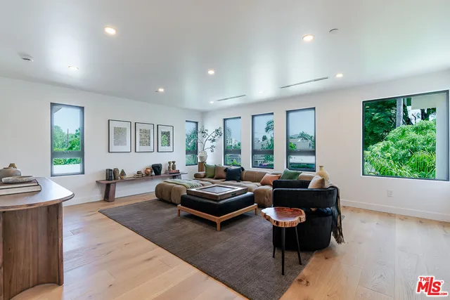a living room with furniture and floor to ceiling windows