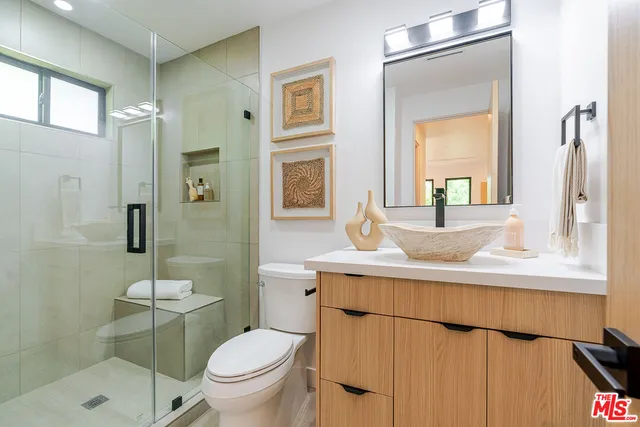 a bathroom with a toilet a sink and a mirror