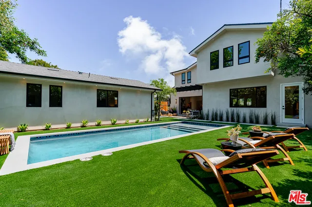 a view of a house with swimming pool and sitting area