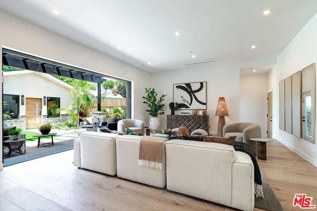 a living room with furniture a large window and a chandelier
