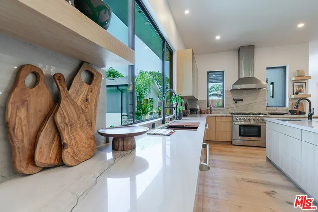 a kitchen with stainless steel appliances granite countertop a stove a sink and a refrigerator