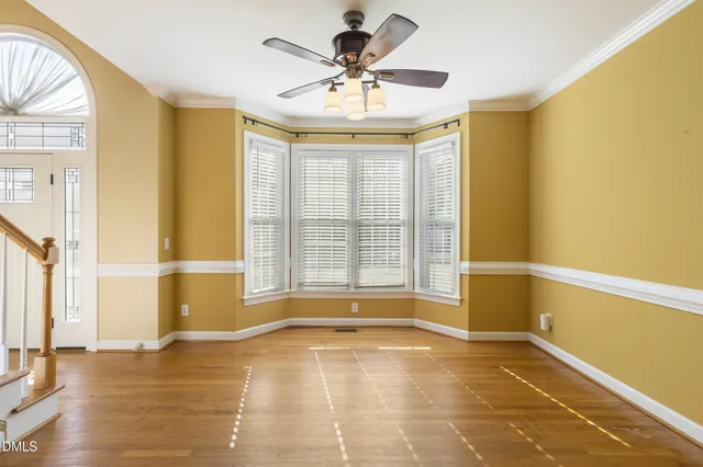a view of an empty room with a window and a kitchen view