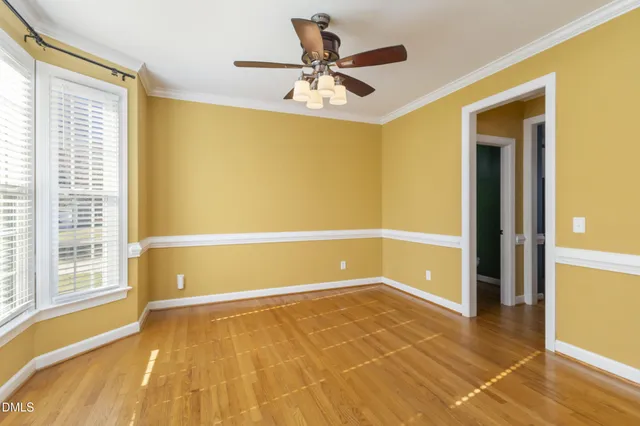 a view of an empty room with a window and a ceiling fan