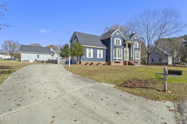 a view of a big house with a big yard and large trees