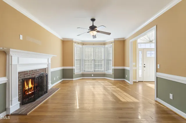 a view of an empty room with window and fire place