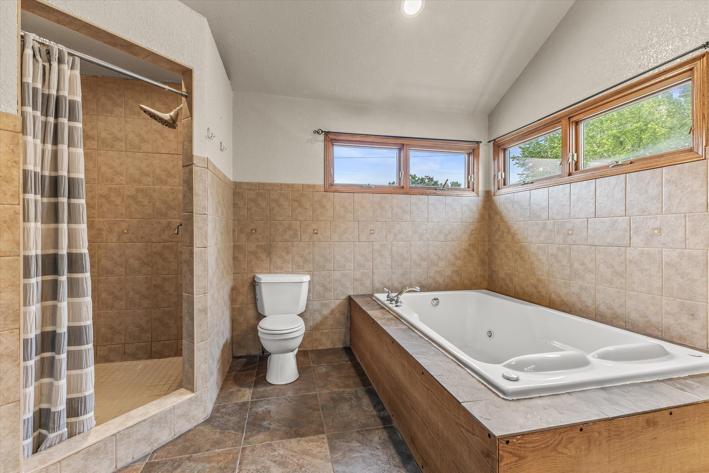 2925 North Main Street Racine, WI 53402 - Photo 10 of 23 Featuring a soaking tub, walk-in tiled shower, and abundant natural light, this spacious bath offers the perfect place to begin and end each day.
