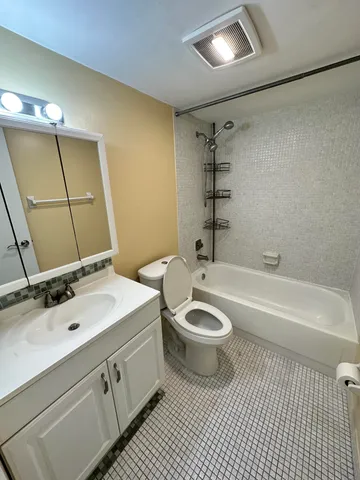 a bathroom with a sink a toilet a mirror and bathtub