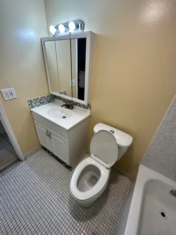a bathroom with a sink toilet and mirror