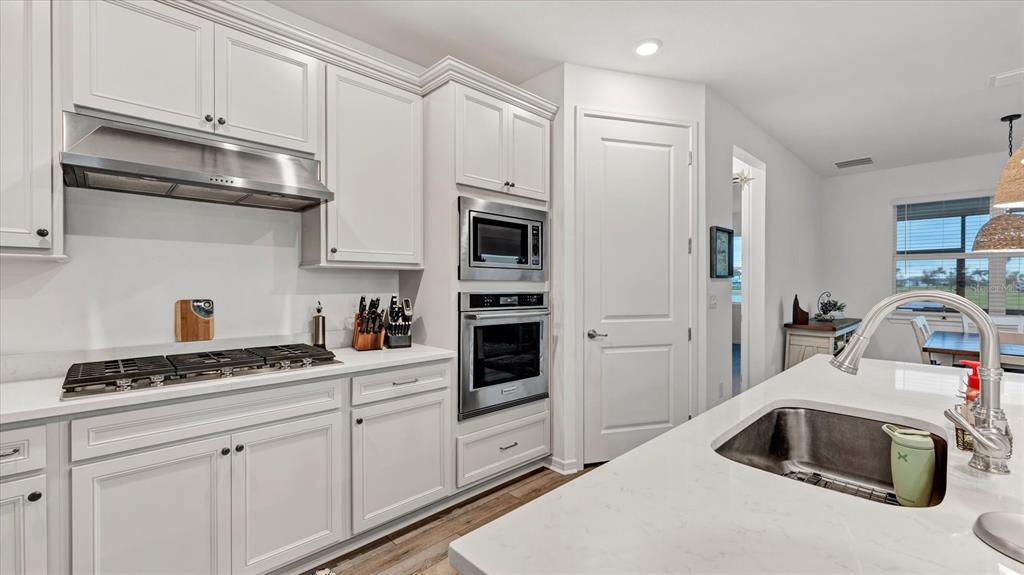 8705 Coastal Key Way Palmetto, FL 34221 - Photo 11 of 64 a kitchen with stainless steel appliances granite countertop a sink and cabinets