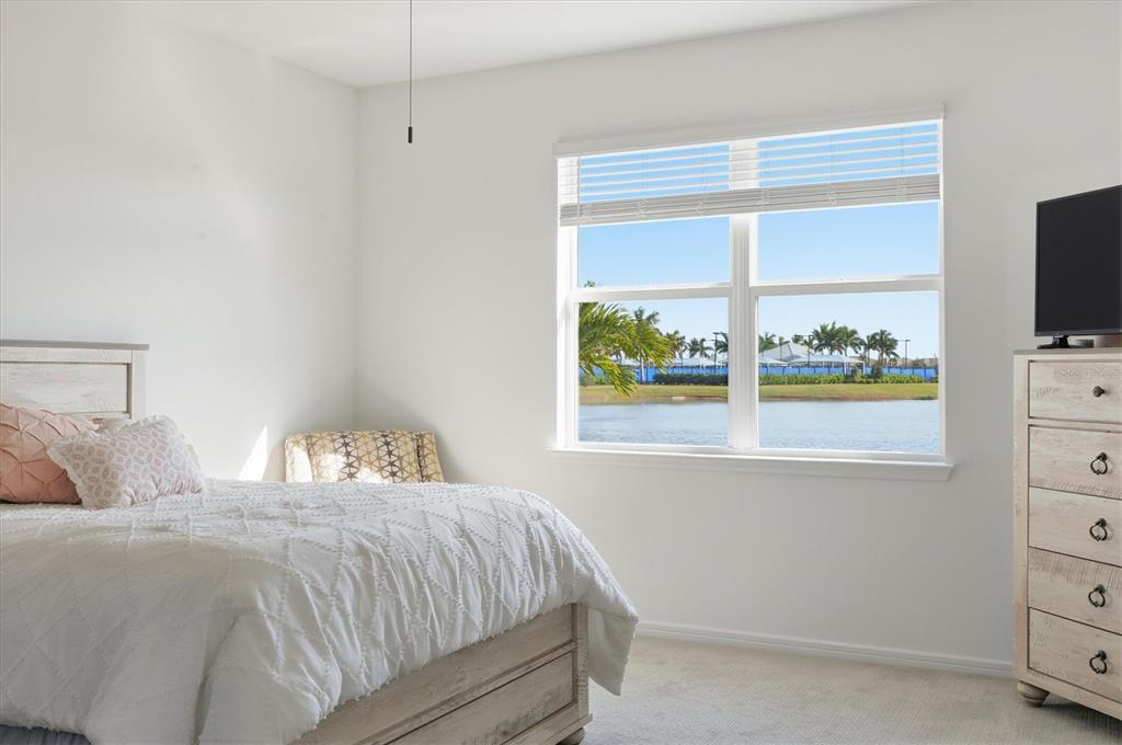 8705 Coastal Key Way Palmetto, FL 34221 - Photo 17 of 68 a bedroom with a bed and a flat tv screen on dresser