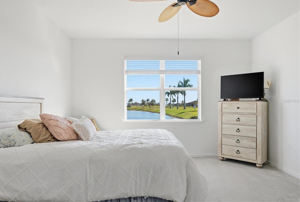 8705 Coastal Key Way Palmetto, FL 34221 - Photo 18 of 68 a bedroom with a bed and painting on the wall