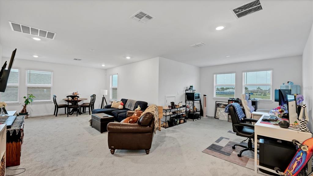 8705 Coastal Key Way Palmetto, FL 34221 - Photo 24 of 64 a living room with furniture a flat screen tv and a large window