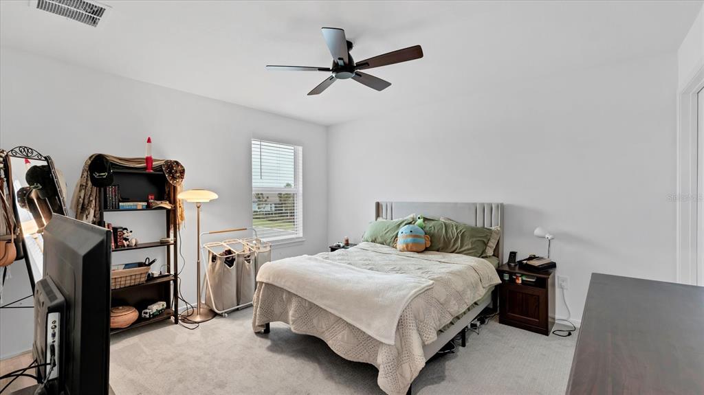 8705 Coastal Key Way Palmetto, FL 34221 - Photo 29 of 68 a bedroom with a bed a couch and a window