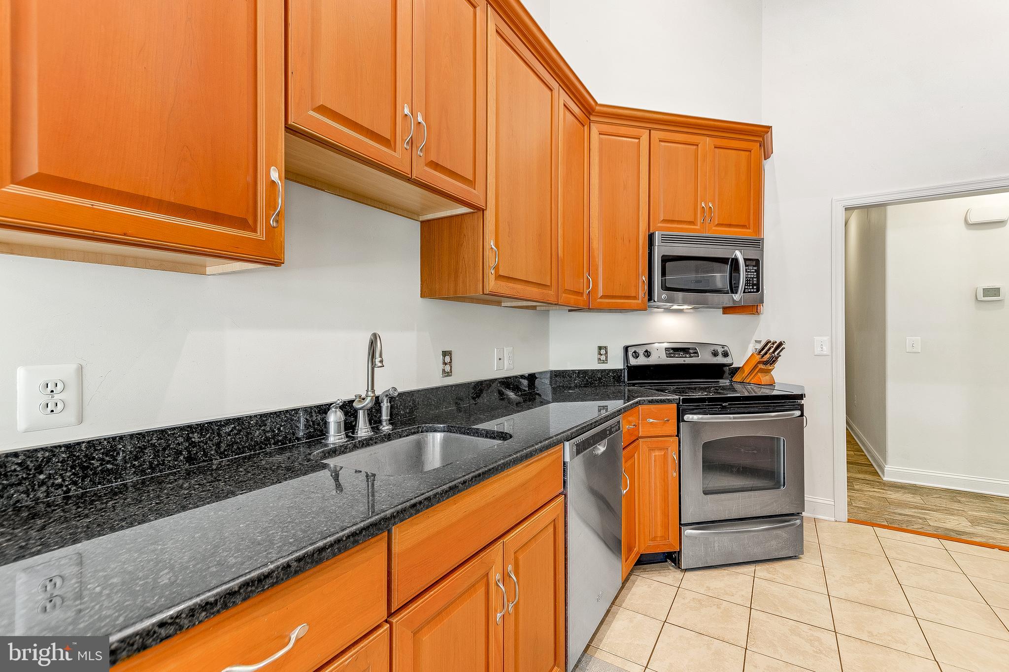 1808 Wilson Road Huntingtown, MD 20639 - Photo 21 of 53 a kitchen with stainless steel appliances granite countertop a sink stove and cabinets