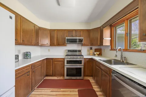 a kitchen with stainless steel appliances granite countertop a stove a sink and a microwave
