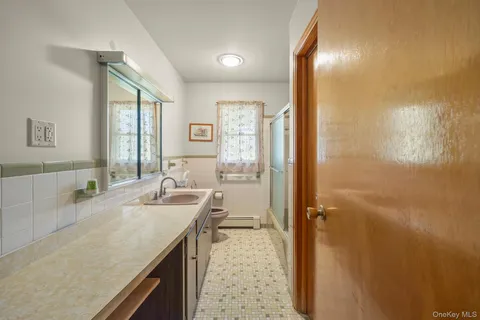 a bathroom with a granite countertop sink a mirror and a bathtub