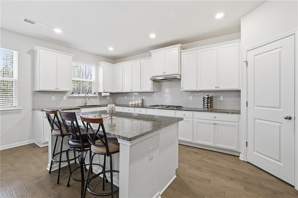 175 Paxton Lane Jefferson, GA 30549 - Photo 8 of 39 a kitchen with granite countertop white cabinets stainless steel appliances and window