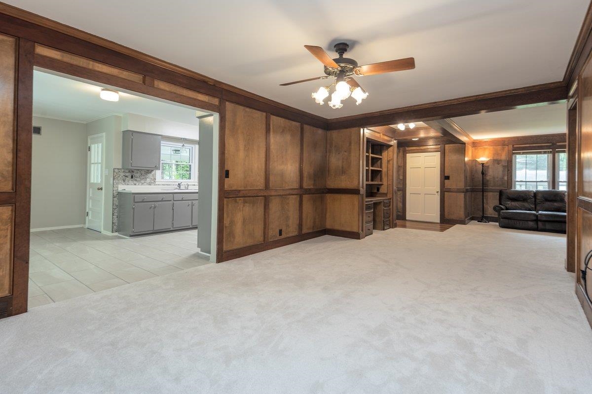 670 Peterson Lake Road Collierville, TN 38017 - Photo 16 of 37 Spacious living area featuring light-toned carpeting and extensive wood paneling