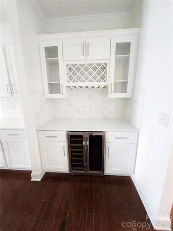 an empty room with wooden floor and cabinet