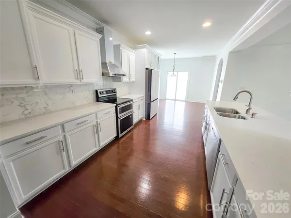 a kitchen with granite countertop white cabinets and stainless steel appliances