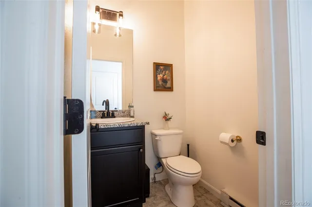 a bathroom with a granite countertop toilet and a sink