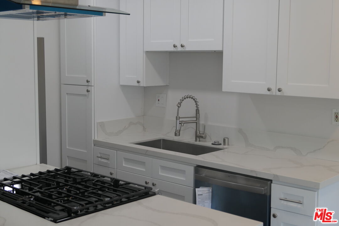 10836 Camarillo Street, Unit 3 North Hollywood, CA 91602 - Photo 3 of 12 a kitchen with white cabinets and sink