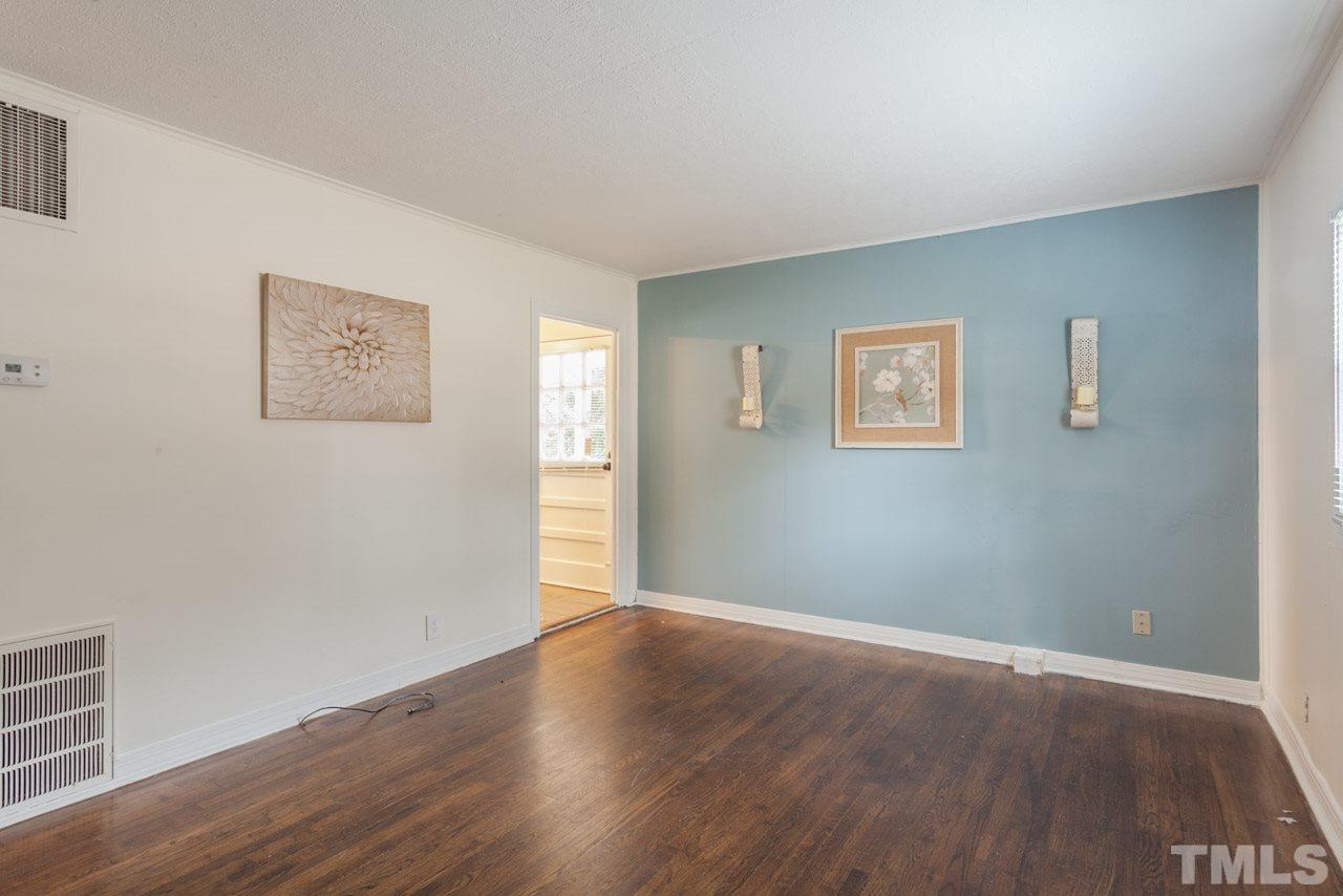 1213 Kent Road Raleigh, NC 27606 - Photo 2 of 6 a view of an empty room with wooden floor and a window