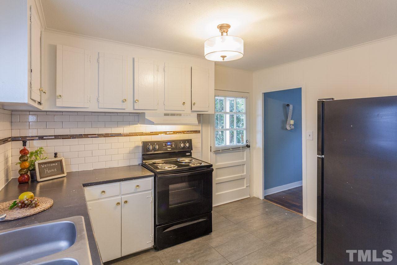 1213 Kent Road Raleigh, NC 27606 - Photo 3 of 6 a kitchen with stainless steel appliances granite countertop a refrigerator and a stove top oven