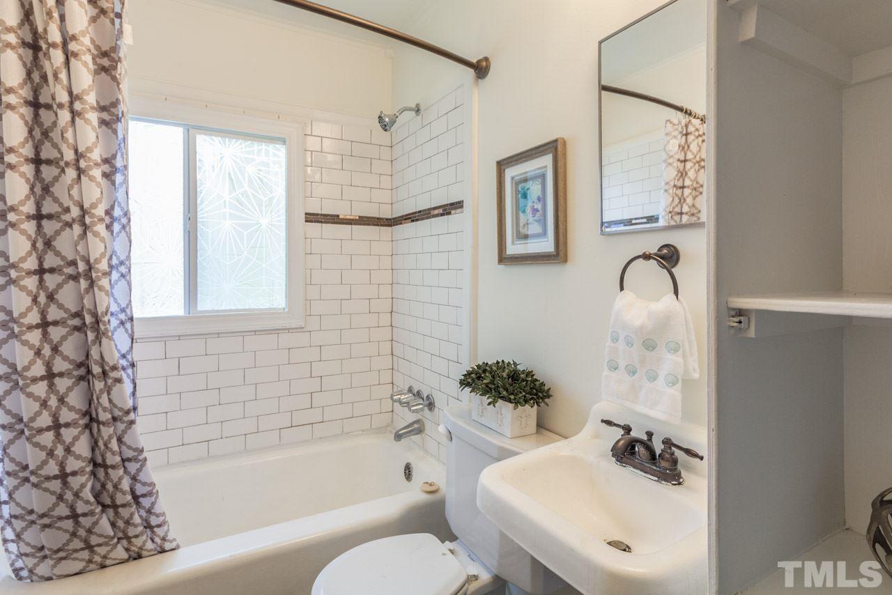 1213 Kent Road Raleigh, NC 27606 - Photo 4 of 6 a bathroom with a sink toilet and shower