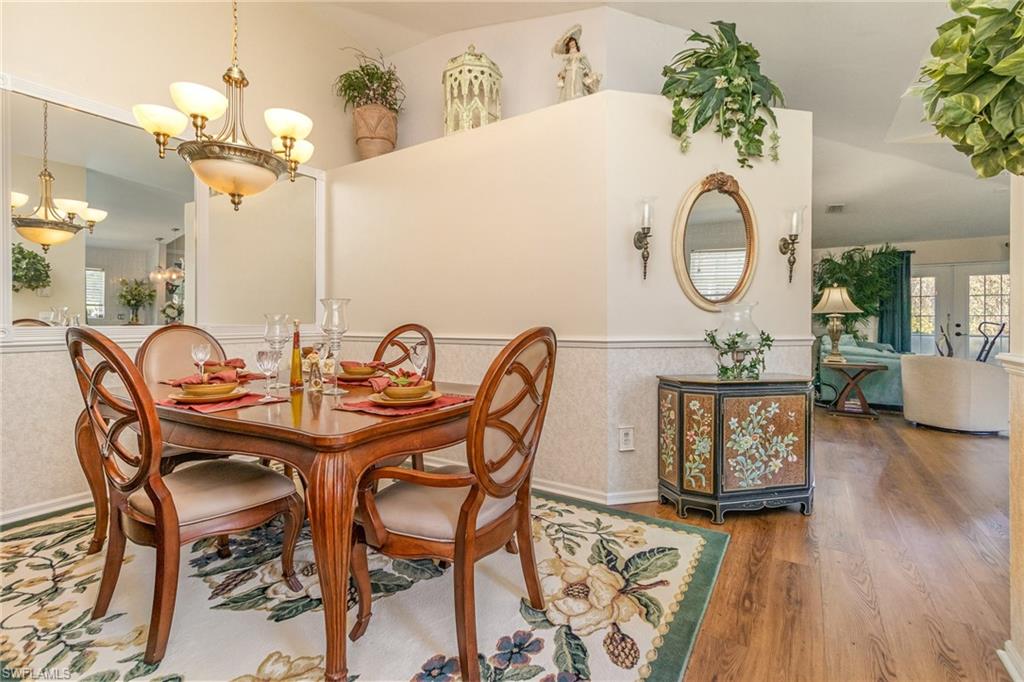 367 Dover Place, Unit 1006 Naples, FL 34104 - Photo 11 of 31 a view of a dining room and hall with wooden floor
